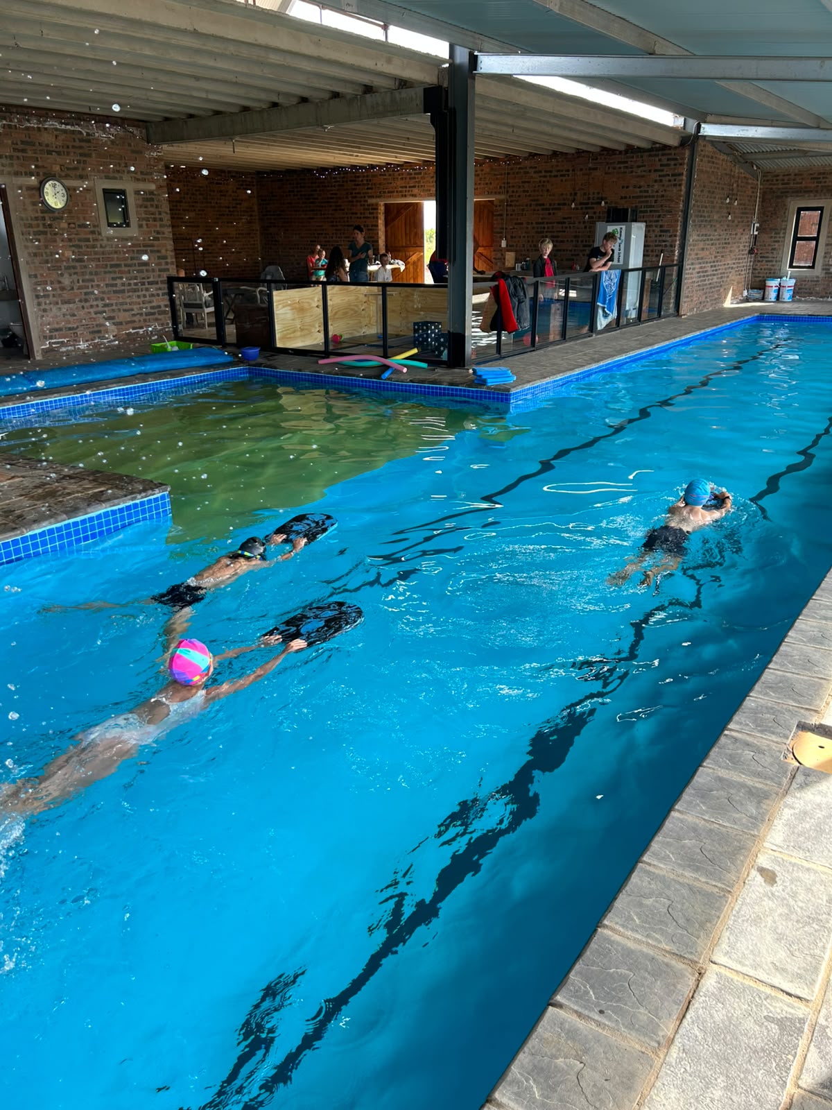 Swimmers doing kickboard drills in the lane pool