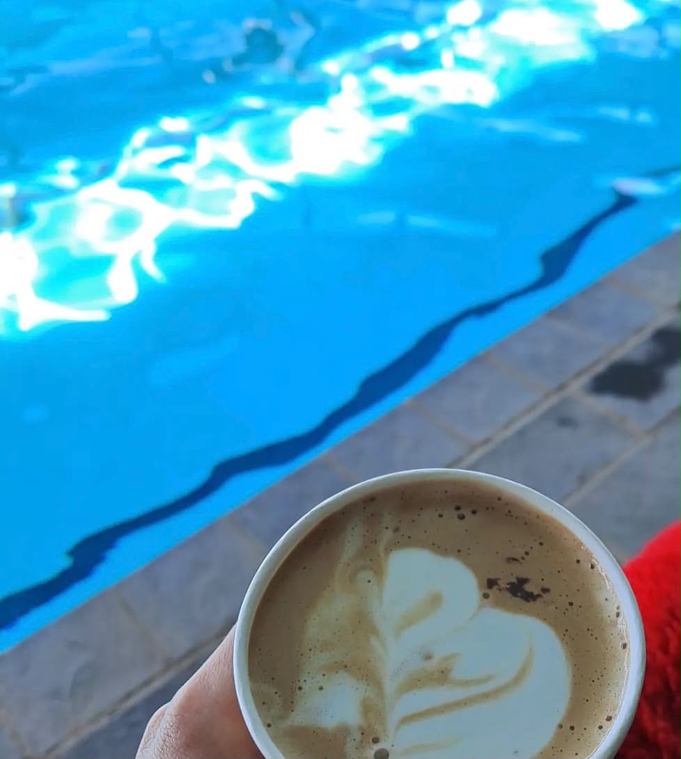 Latte art coffee cup by the poolside